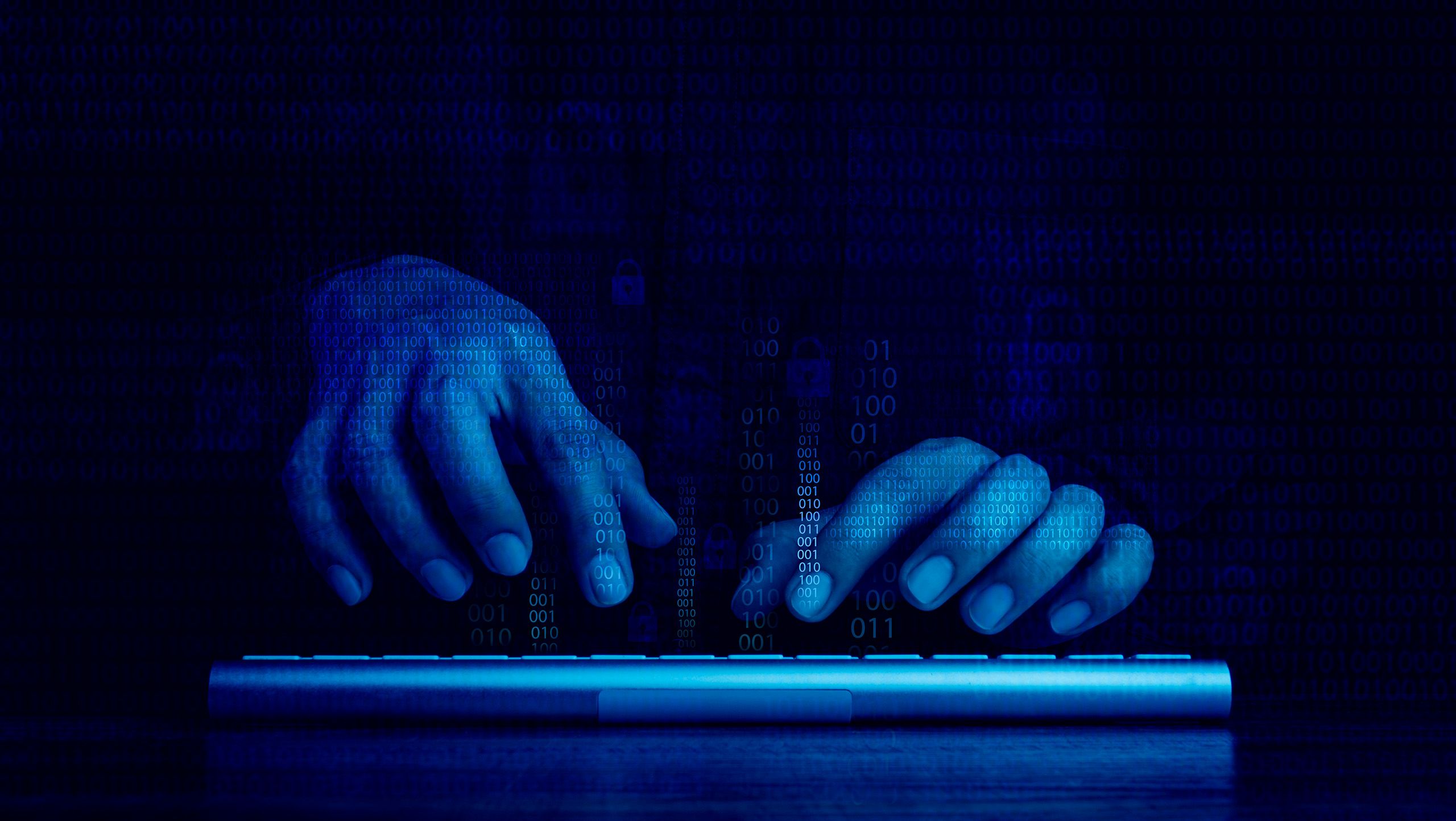 Digital binary code data numbers and secure lock icons on hacker' hands working with keyboard computer on dark blue tone background.